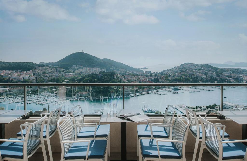a table and chairs on a balcony with a view of the water at Hotel Adria in Dubrovnik