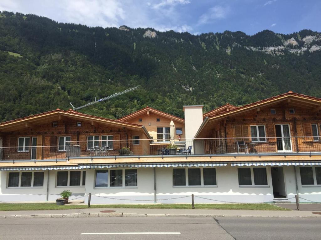 a large building with a mountain in the background at Swiss Chalet Holidays Ringgenberg in Ringgenberg