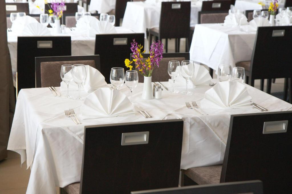 a group of tables with white table linen and flowers on them at Hotel Adria in Dubrovnik