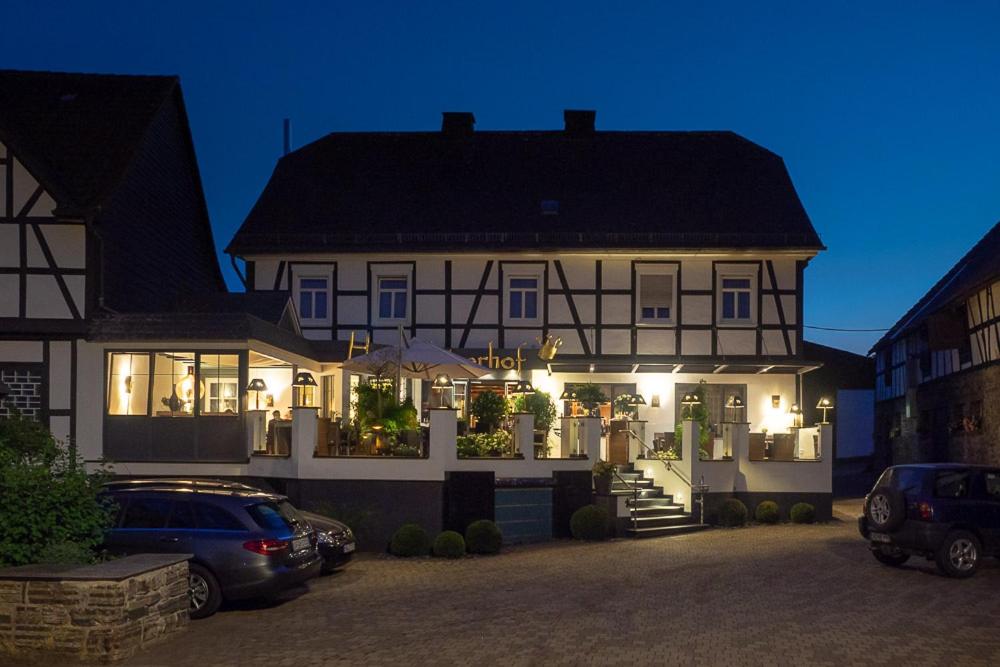 een groot wit huis met auto's geparkeerd voor het bij Hotel Kaiserhof in Medebach