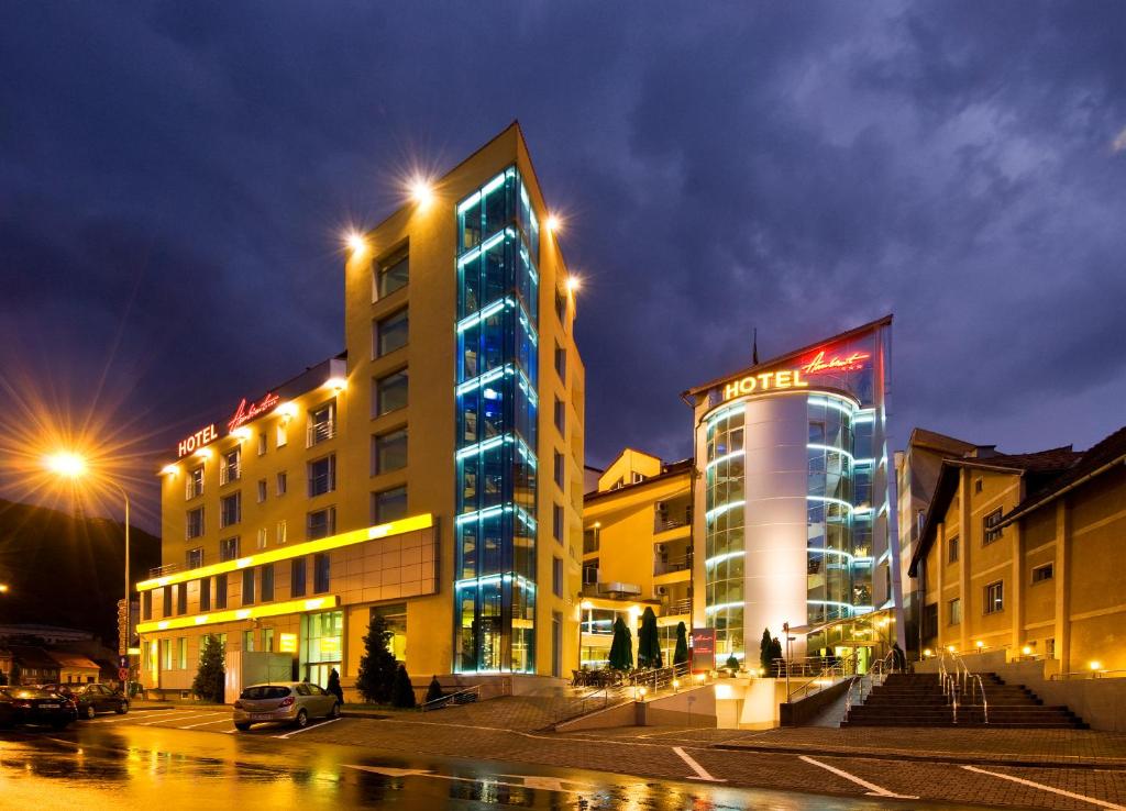 a city street at night with a large building at Hotel Ambient in Braşov
