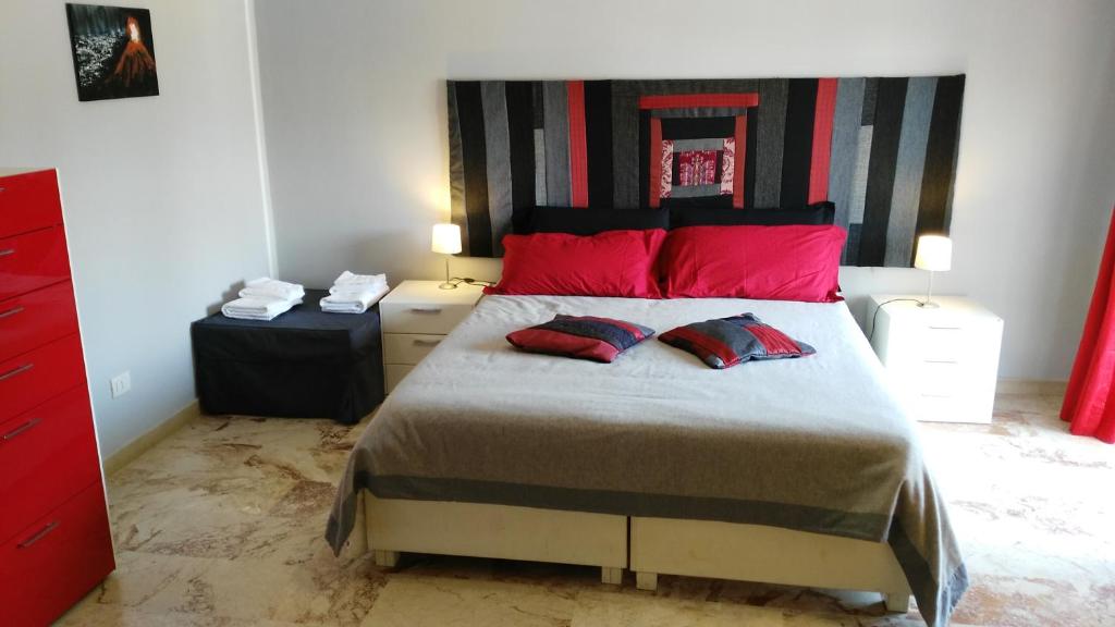 ザッフェラーナ・エトネーアにあるCartoline Dall'Etna B&bのベッドルーム1室(大型ベッド1台、赤い枕付)