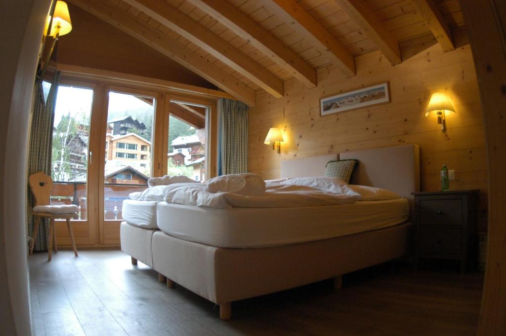 a bedroom with a large bed in a room with a window at Chalet Guggenbiel in Zermatt