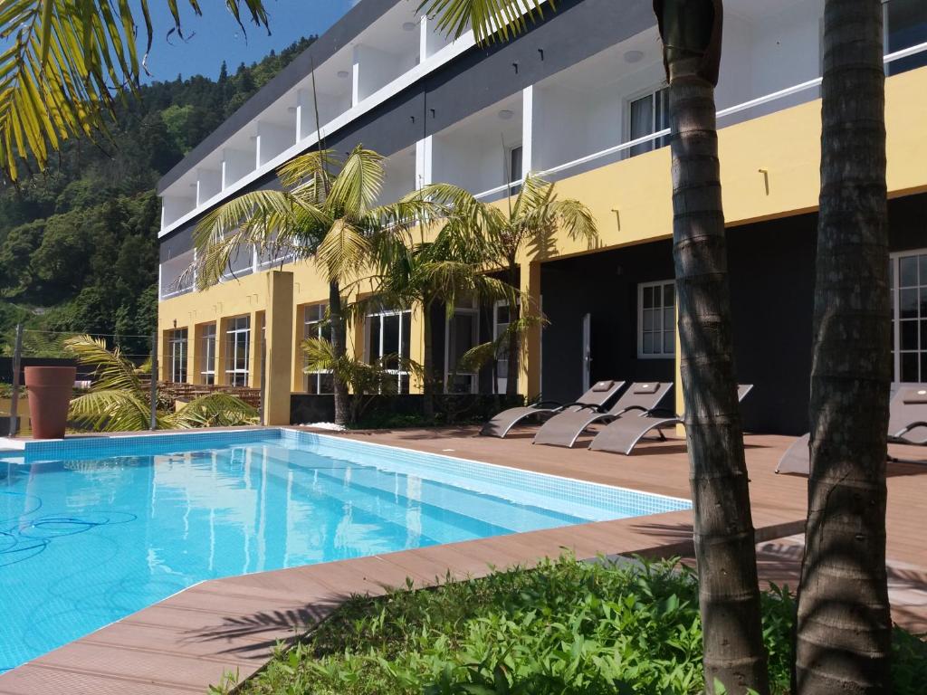 a swimming pool in front of a building at Vista Do Vale in Furnas