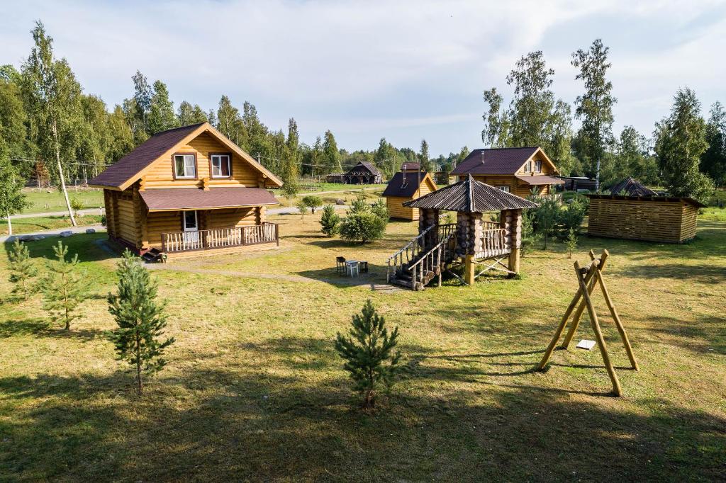 eine Gruppe von Häusern auf einem Feld mit Bäumen in der Unterkunft Cottages Ozerny Bereg in Belich'ye