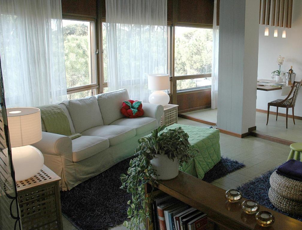 un soggiorno con divano e tavolo di Prestigioso appartamento Lagomare a Torre del Lago Puccini