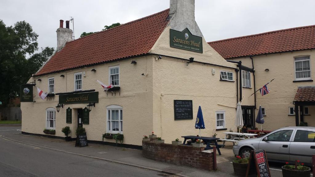 um edifício na esquina de uma rua em The cabin saracens head em Chapel Saint Leonards