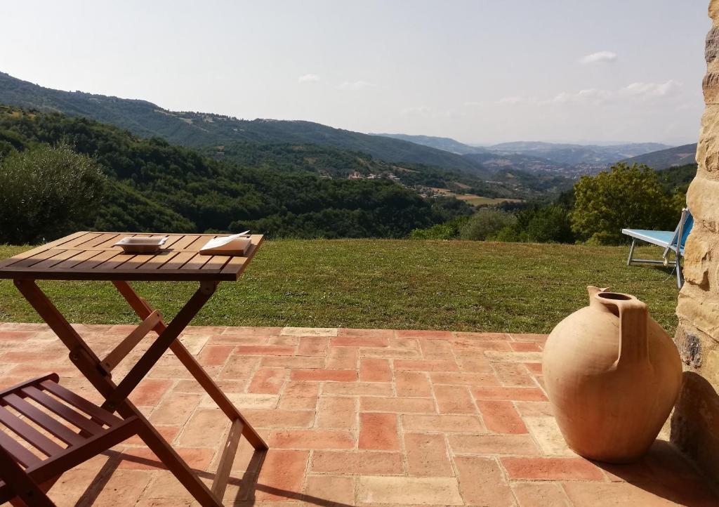 una mesa, una silla y un jarrón en el patio en Alba dei Due Soli B&B, en Nocera Umbra