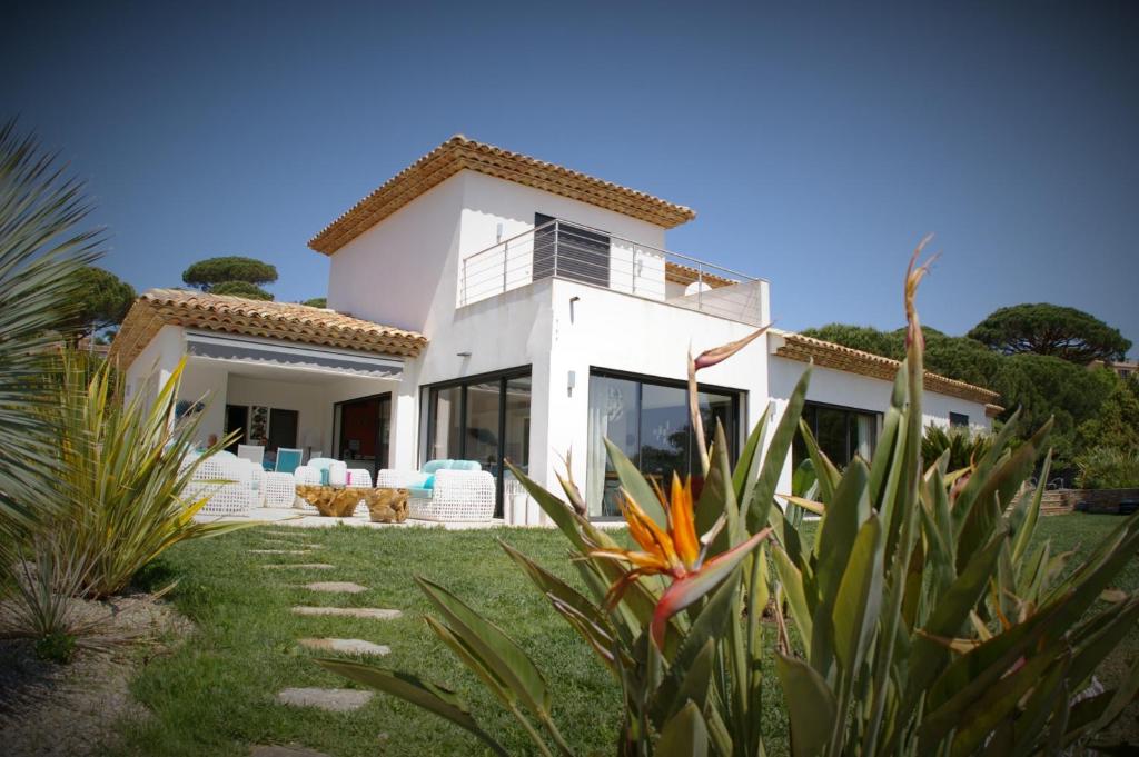 ein weißes Haus mit einem Hof mit Pflanzen in der Unterkunft Villa Happiness Sainte-Maxime in Sainte-Maxime