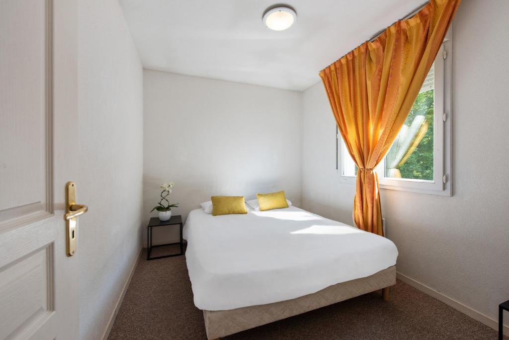 1 dormitorio con cama y ventana en Appart'City Classic Dijon - Toison D'Or en Dijon