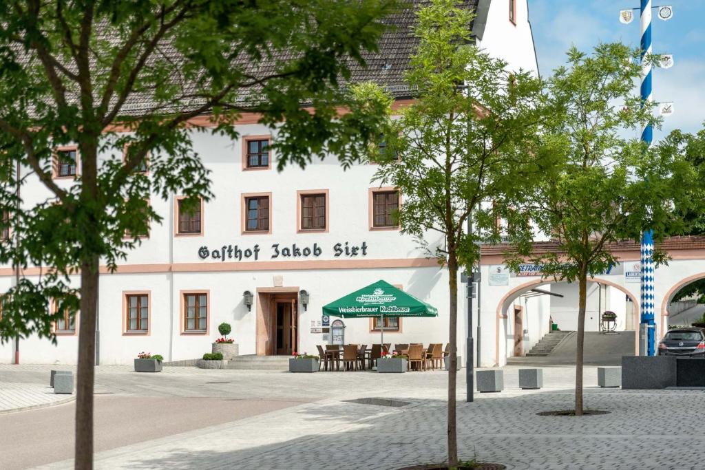 un bâtiment dans une ville avec des arbres devant elle dans l'établissement Hotel Sixt, à Rohr