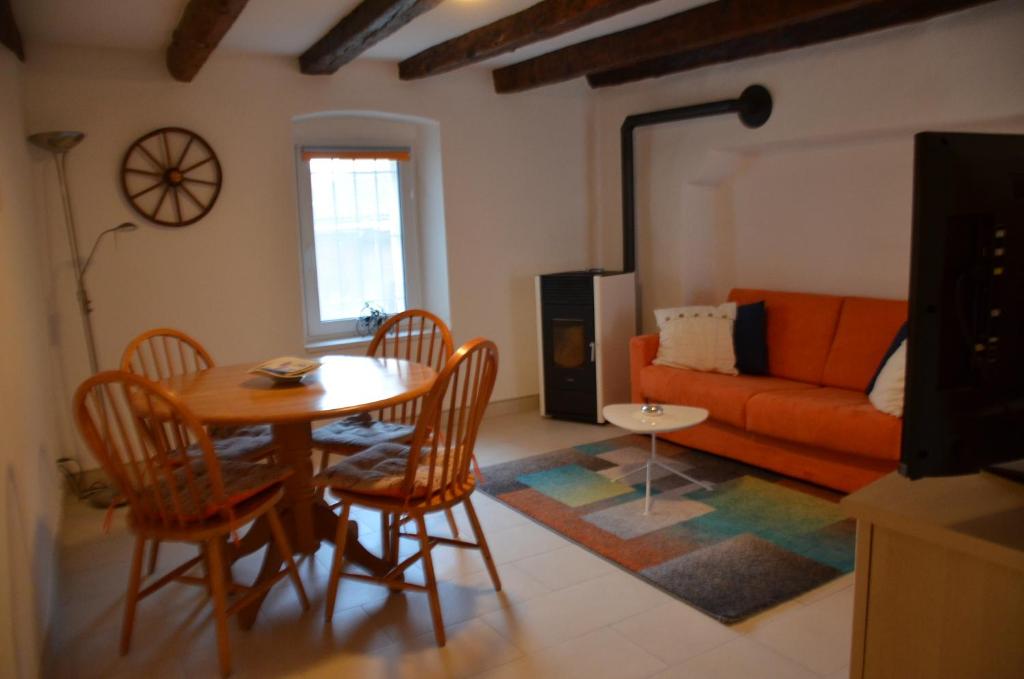 sala de estar con mesa, sillas y sofá en ca da la nona, en Cavigliano