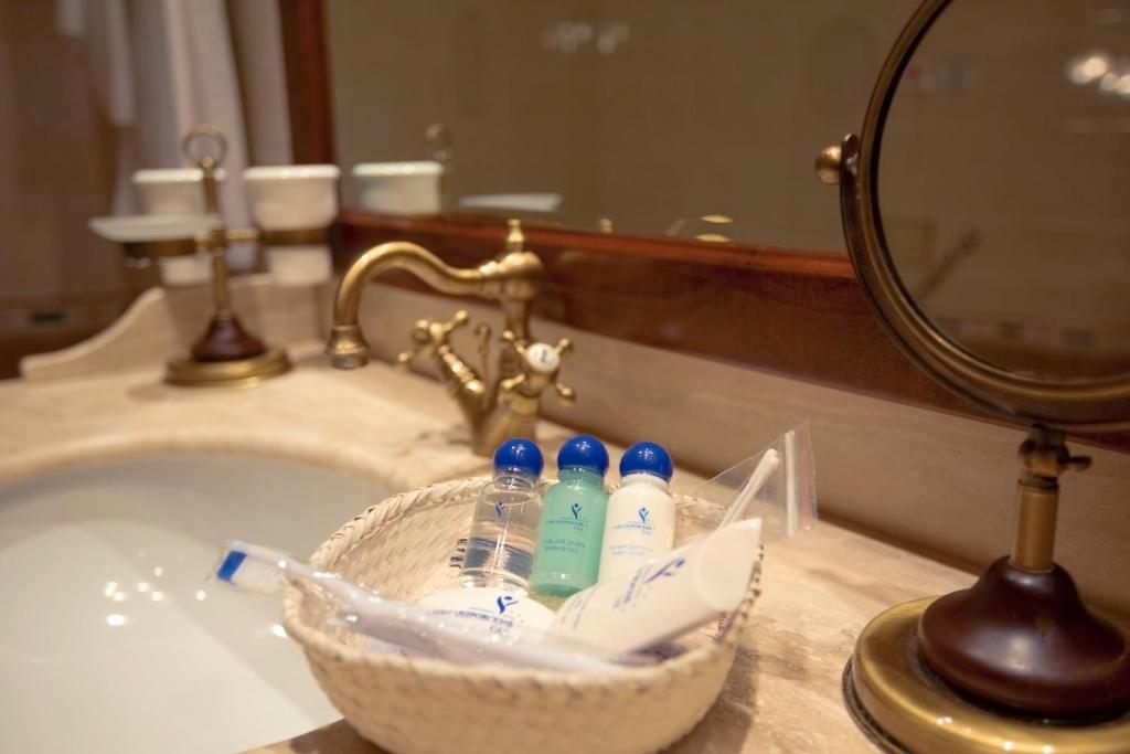 a basket of toothbrushes and toothpaste on a bathroom sink at Alexandrovsky Garden in Nizhny Novgorod