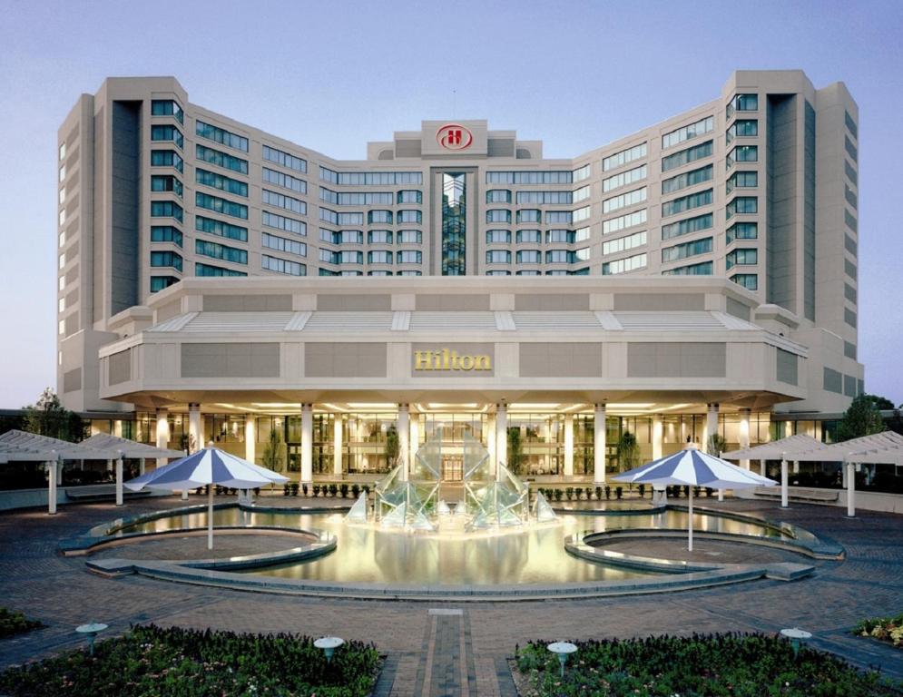 a hotel with a fountain in front of a building at Hilton East Brunswick in East Brunswick