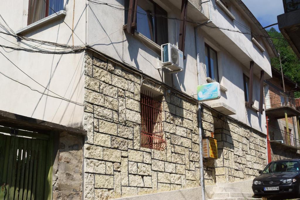 um edifício de pedra com um sinal na lateral em Guest House Perla em Bachkovo