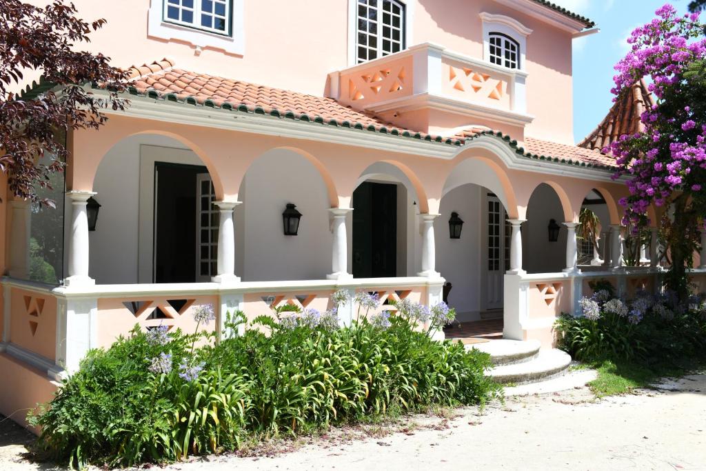 une maison avec des fleurs devant elle dans l'établissement Quinta da Fogueira, à Anadia