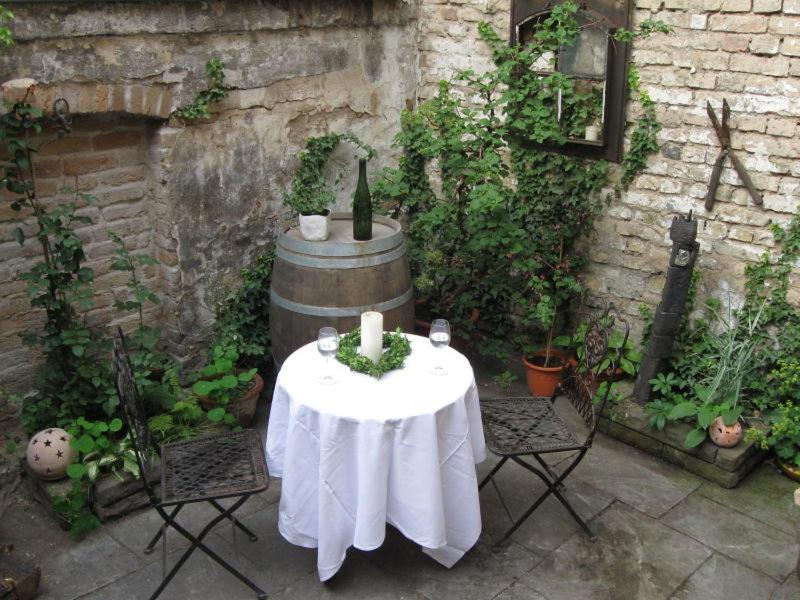 a table with a candle and two chairs in a courtyard at Zwischen-Rhein-und-Reben, zentral, barrierefrei in Speyer