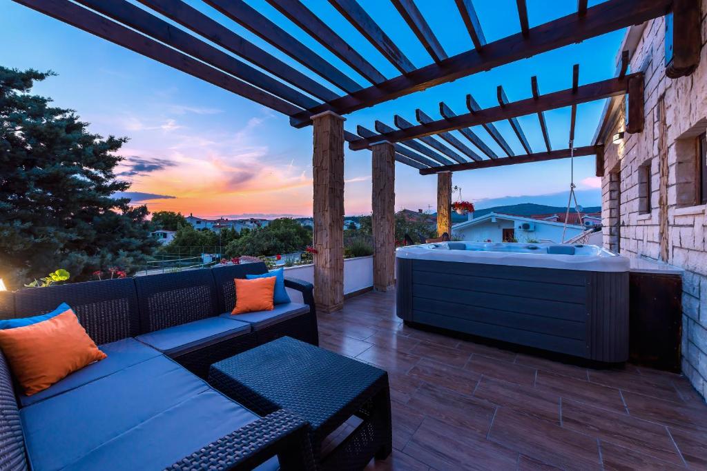 a patio with a couch and a wooden pergola at Villa Maria in Rogoznica