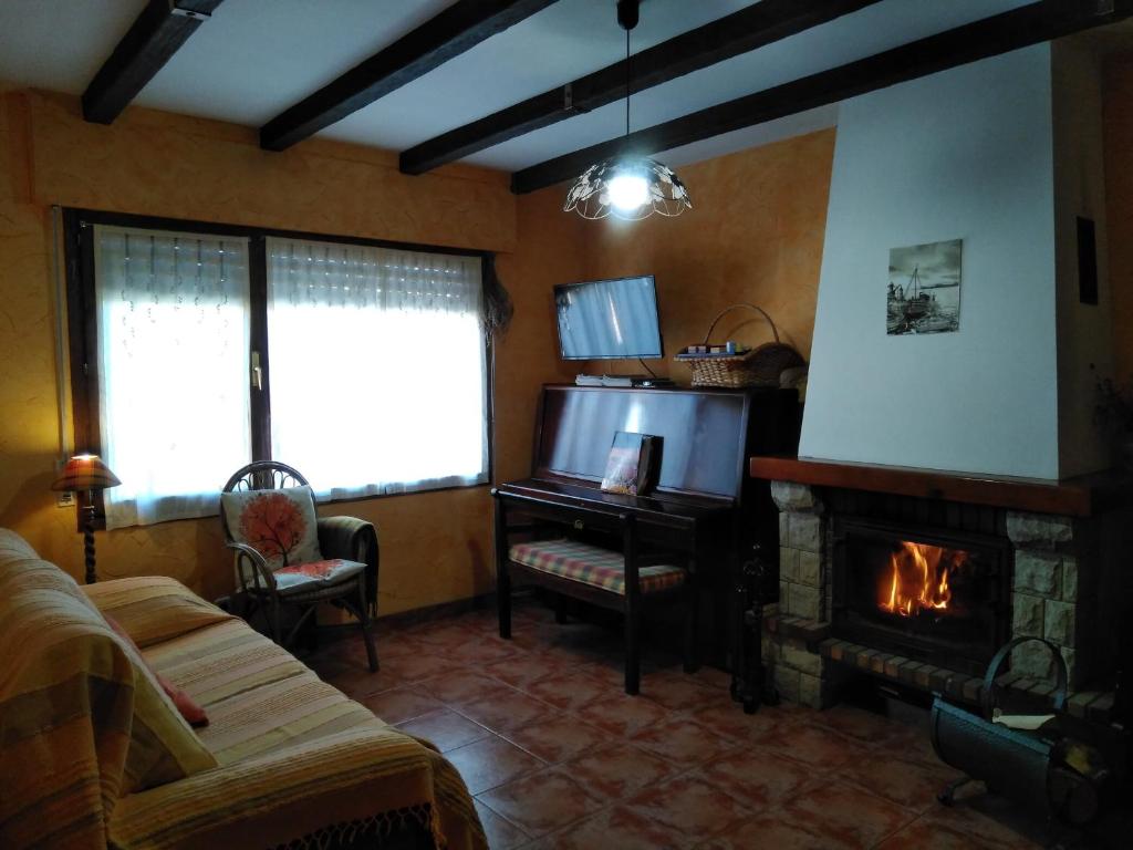 uma sala de estar com lareira e televisão em Casa Galilea em Galilea