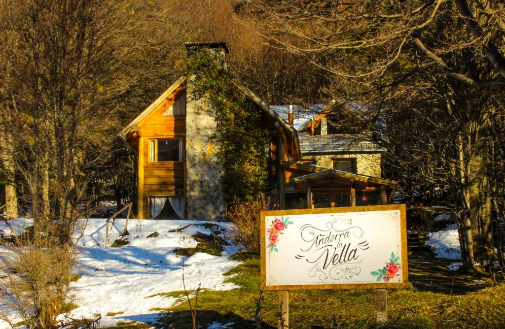 un cartel en frente de una casa en la nieve en Hospedaje Andorra La Vella en Ushuaia