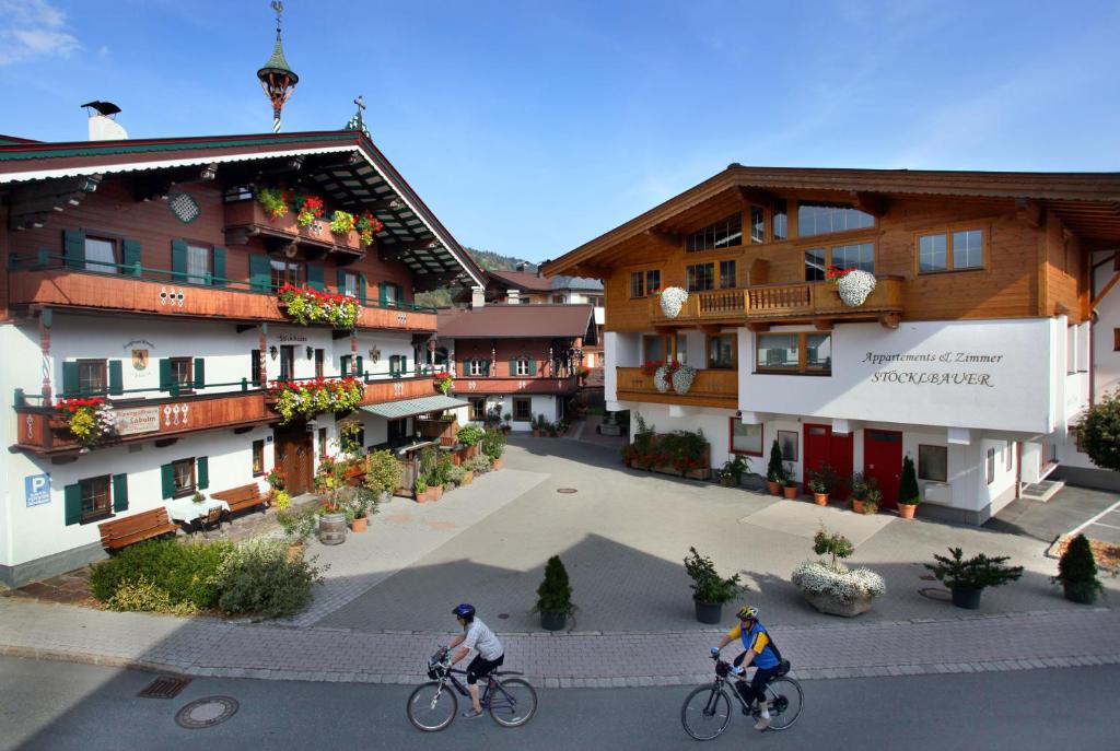 twee personen die fietsen voor een gebouw bij Stöcklbauer in Kirchberg in Tirol