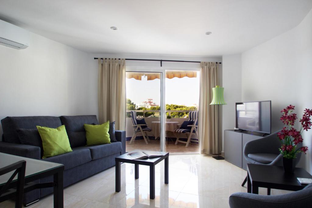 トレモリノスにあるR&E apartmentsのリビングルーム(青いソファ、テーブル付)