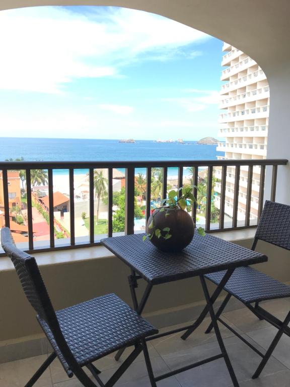 a table and chairs on a balcony with the ocean at Departamento 523 con playa dentro de Hotel en Ixtapa in Ixtapa
