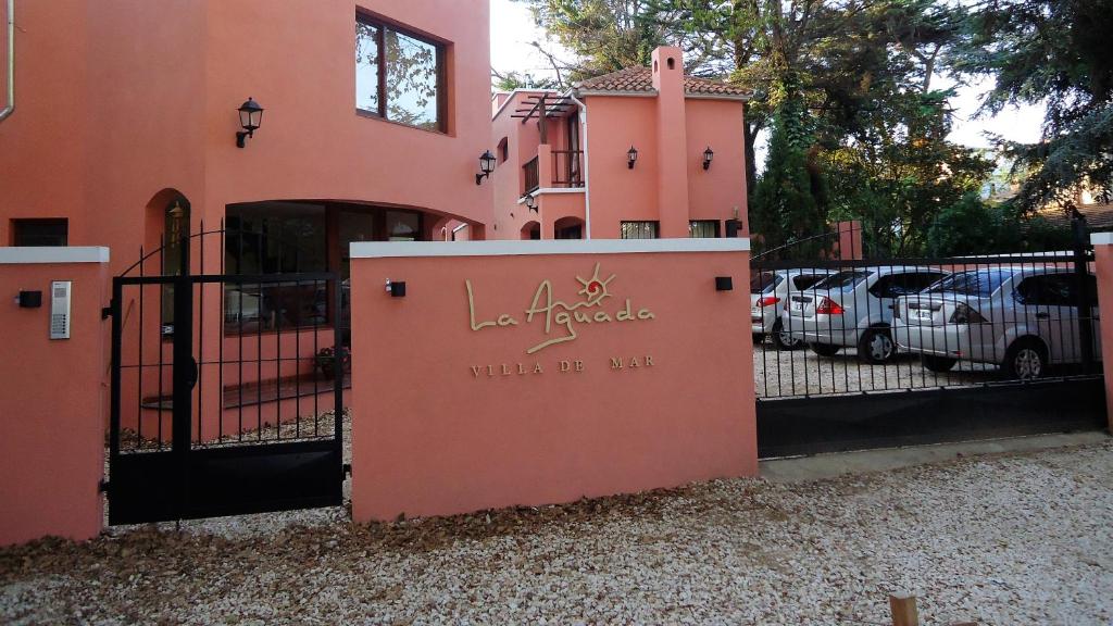 a pink building with a gate with the words wall of hug at LA AGUADA - Villa de Mar in Villa Gesell