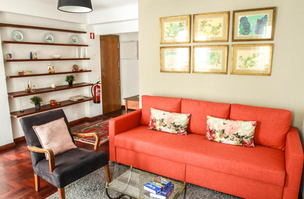 - un salon avec un canapé orange et une chaise dans l'établissement Cozy and Spacious apartment in Graça, Lisbon, à Lisbonne