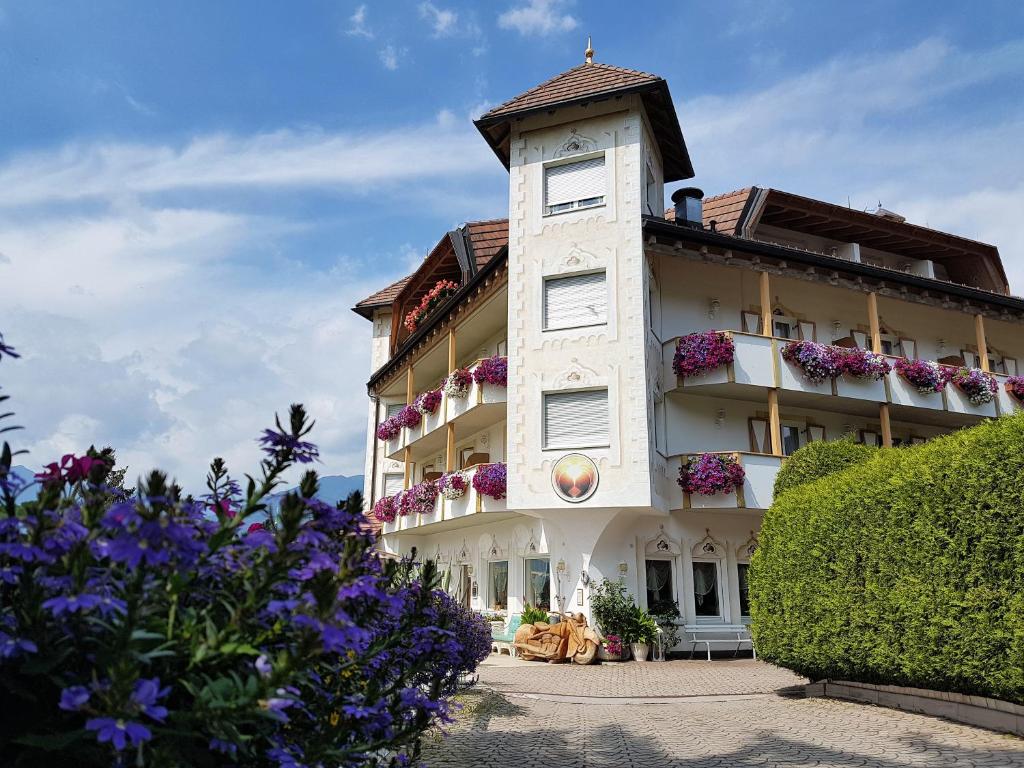 a white building with flowers in front of it at Alpenlandhotel Rodeneggerhof in Rodengo