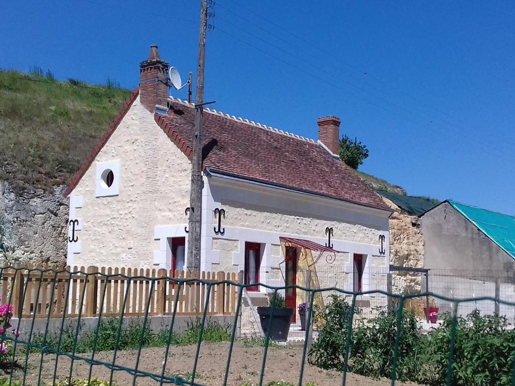 uma casa branca com uma cerca à frente. em Le paradis des caves em Châteauvieux