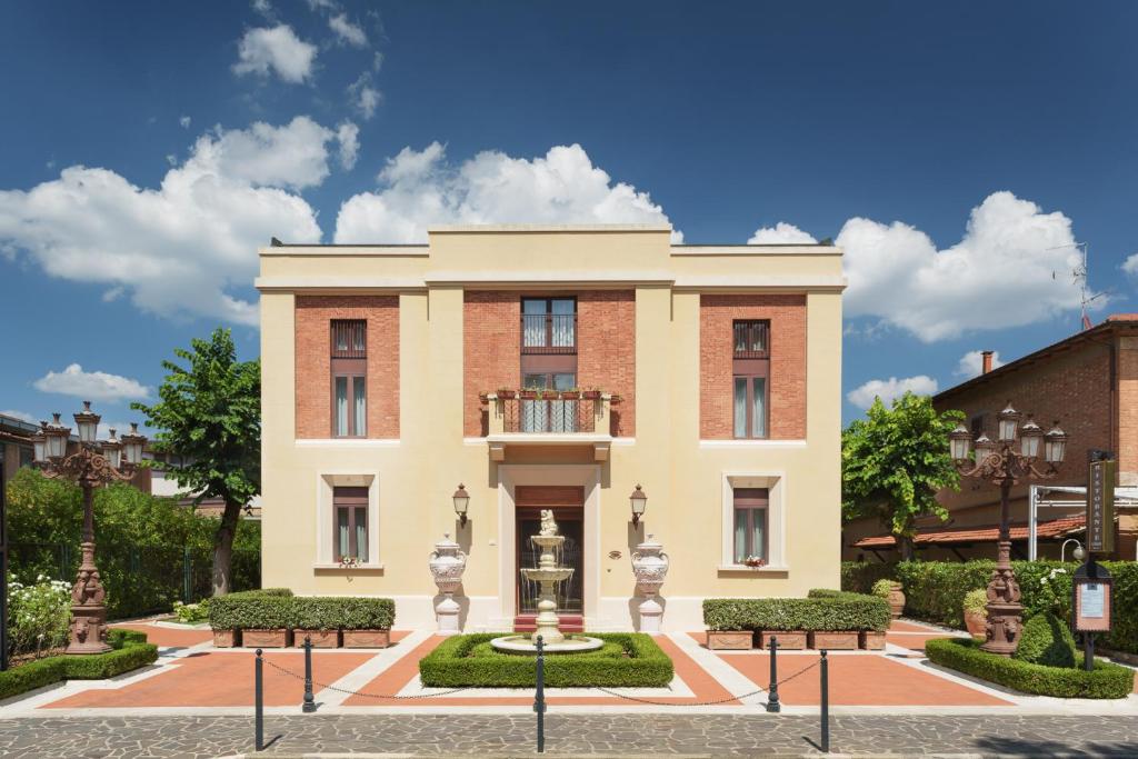 um edifício com uma fonte em frente em Hotel San Gregorio em Pienza