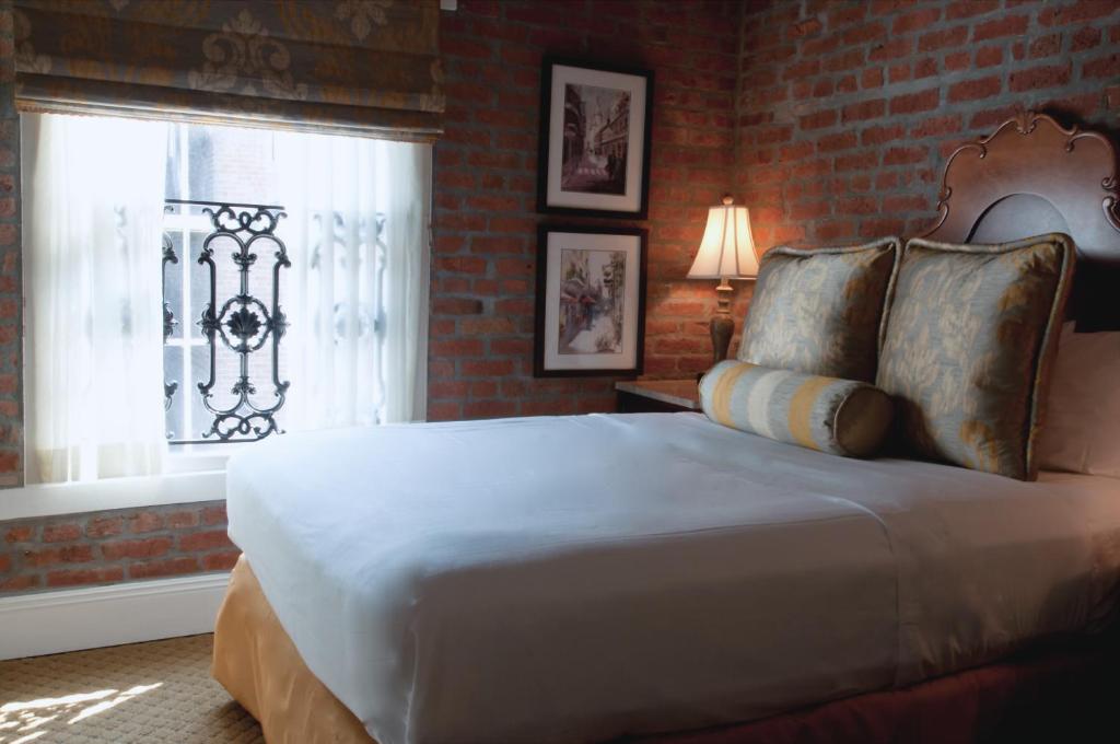 a bedroom with a large bed and a window at French Market Inn in New Orleans