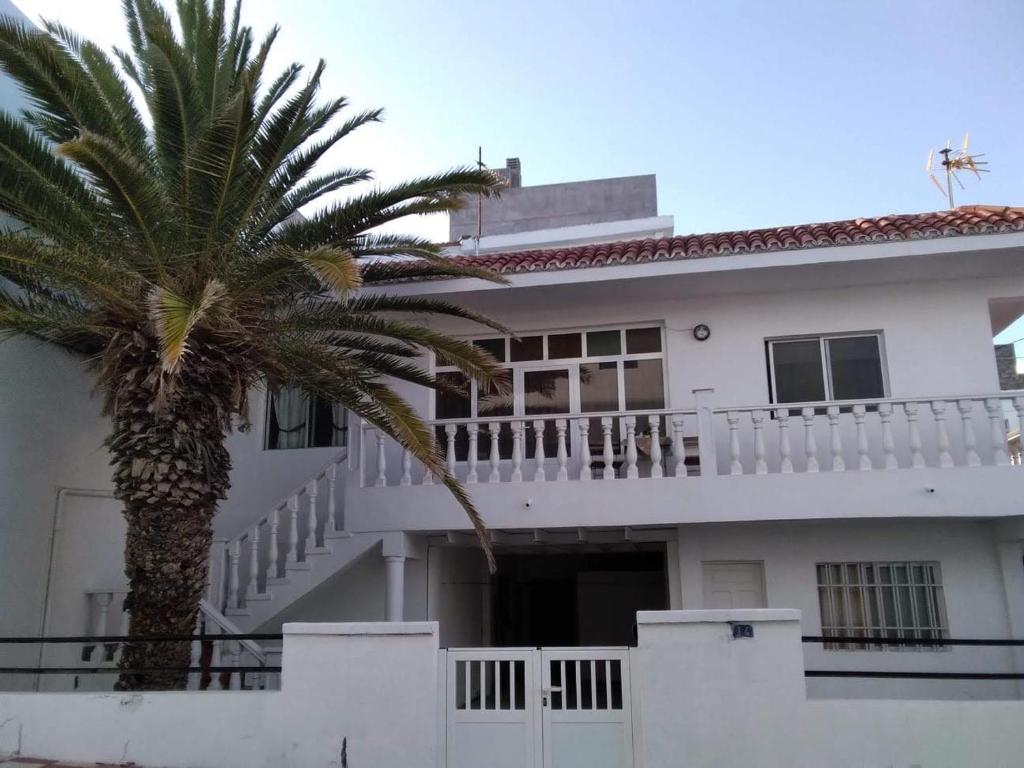 una casa blanca con una palmera delante de ella en Casa Restinga en La Restinga