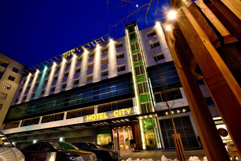 a hotel building at night with cars parked in front at Hotel City in Villach