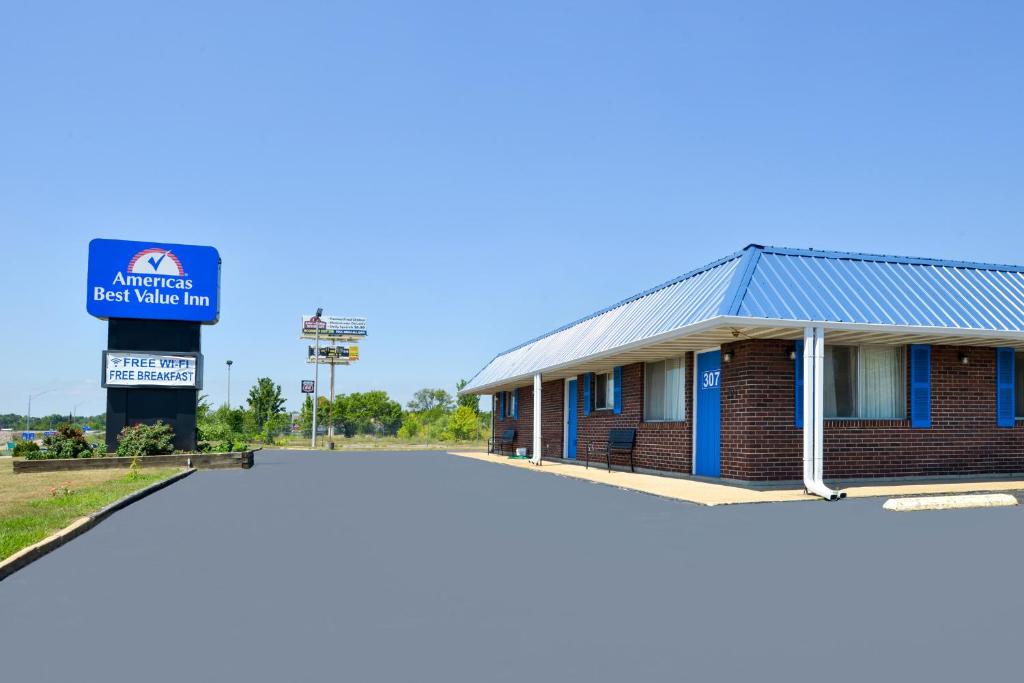 a building at a gas station with a billboard at Americas Best Value Inn Sullivan in Sullivan