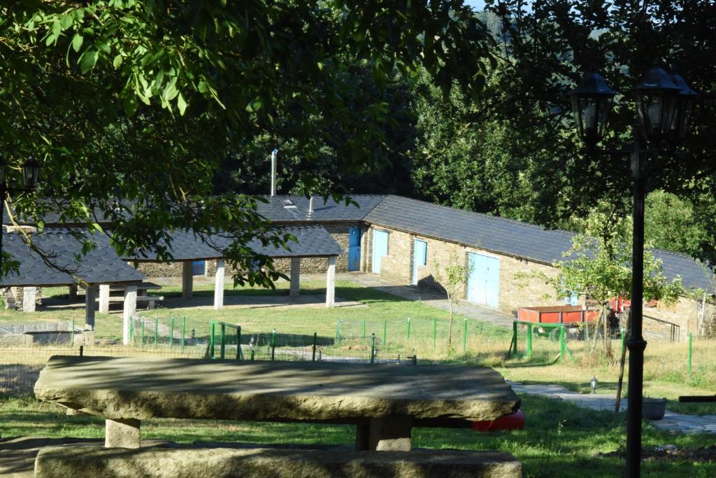 un parque con un grupo de mesas de picnic y árboles en O Albergue en Lugo