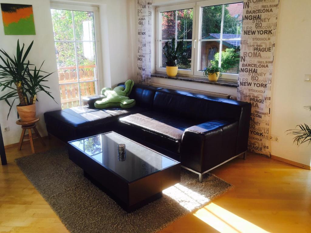 a black leather couch in a living room with a coffee table at Apartment Friedenslinde in Bad Wörishofen