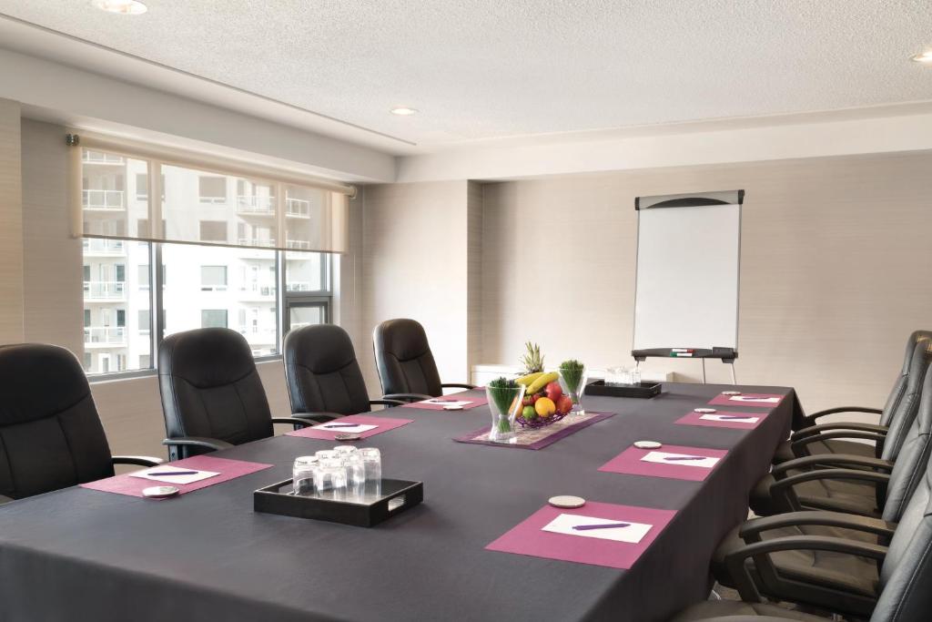 a conference room with a long table and chairs at Coast Edmonton Plaza Hotel by APA in Edmonton