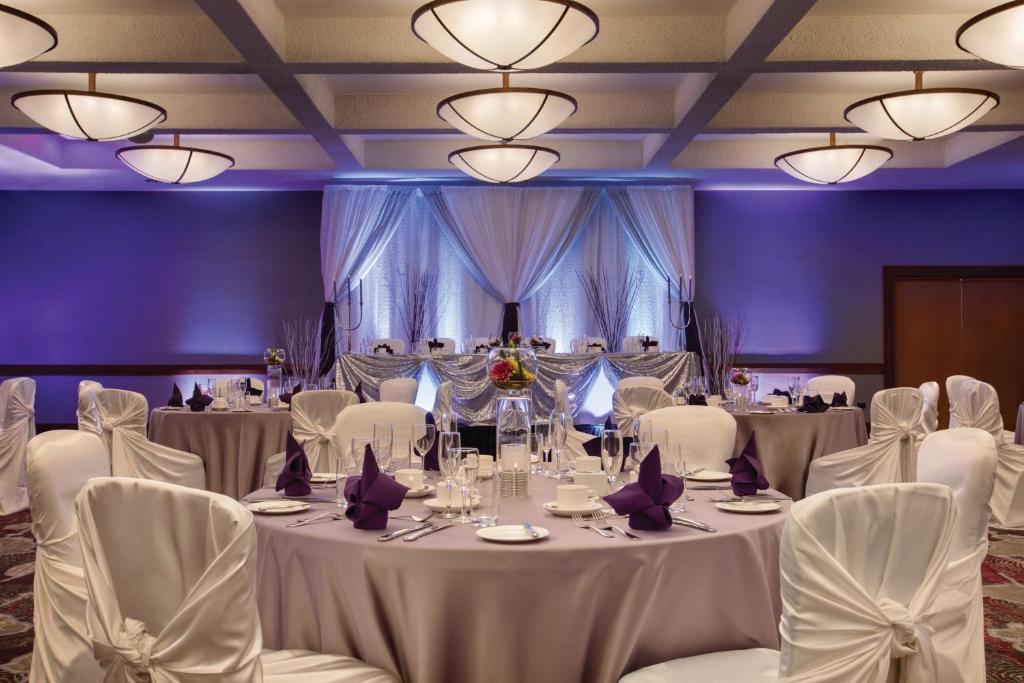 a banquet room with white tables and white chairs at Coast Edmonton Plaza Hotel by APA in Edmonton