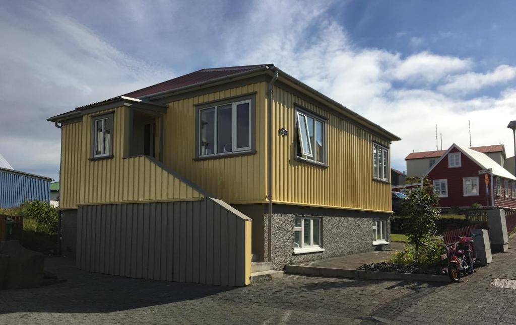 a yellow house with a garage at Garður restored house in Stykkishólmur