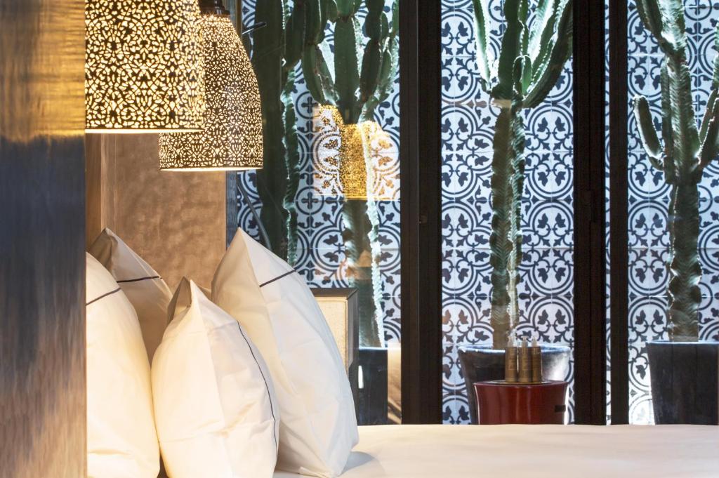 a bedroom with white pillows and a window at Dar Kandi in Marrakech