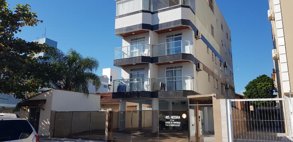 un edificio alto con balcones a un lado. en Apartamento Residencial Messina, en Florianópolis