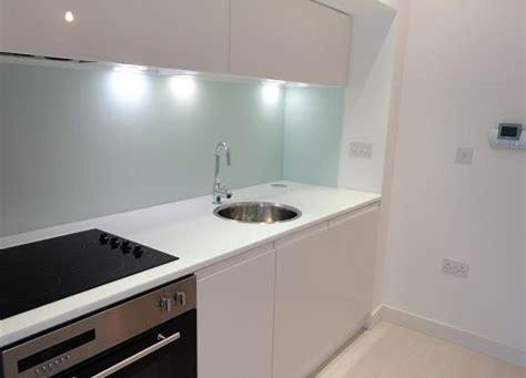een witte keuken met een wastafel en een fornuis bij Serviced Apartments Leeds in Leeds