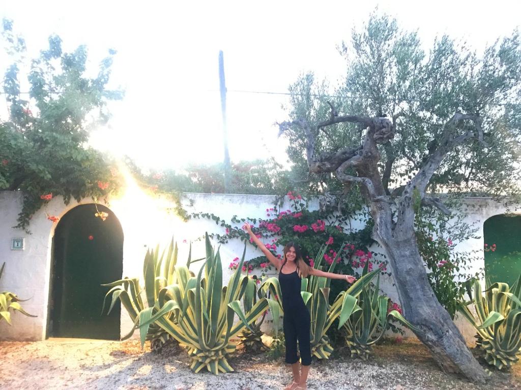 une femme debout devant un arbre dans l'établissement Villa Sara di Puglia, à Castellaneta