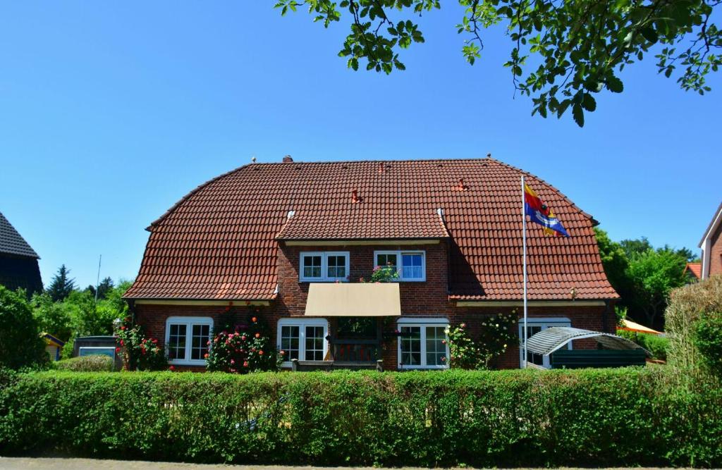 una casa in mattoni marrone con tetto rosso di Landjägerhaus am Südstrand - Wohnung 4 + 5 a Wyk auf Föhr