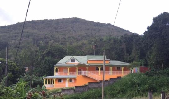 una casa naranja al lado de una montaña en Ô Fil de l'Eau, en Pointe-Noire