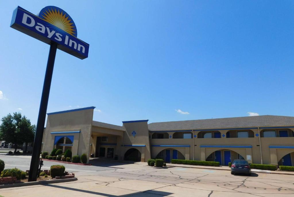 a building with a street sign in front of it at Days Inn by Wyndham Oklahoma City NW Expressway in Warr Acres