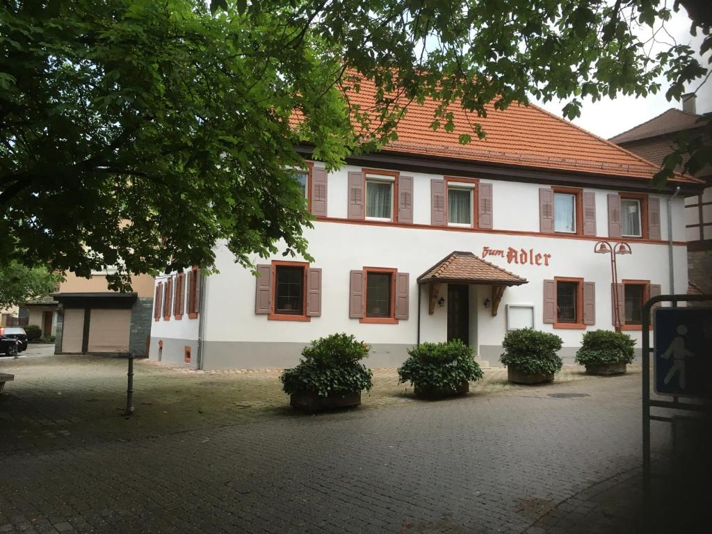 een wit gebouw met een rood dak bij Gasthaus zum Adler in Baden-Baden