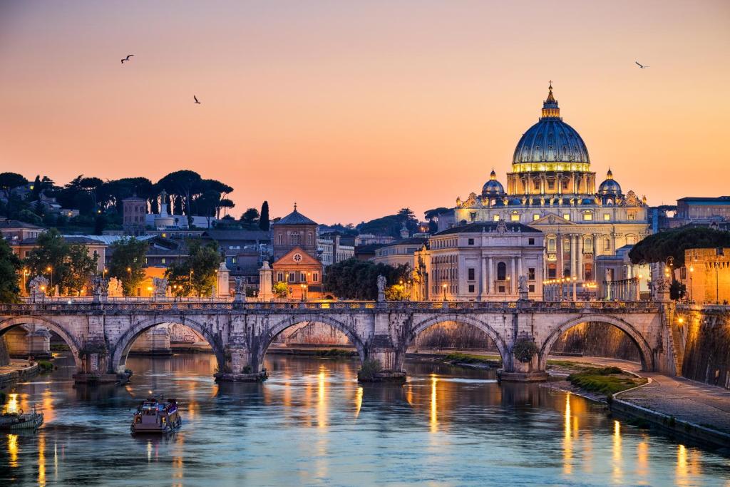 most nad rzeką z budynkiem i katedrą w obiekcie Colosseo Rooms Imperial Rome w Rzymie